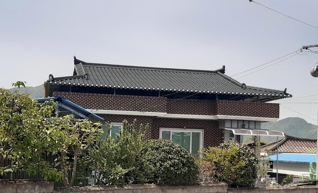벽돌 슬라브로 건축된 집으로 리모델링 하였으며 전체적인 외형이며 담 주위에 유실수 및 꽂나무가 식재되어 있음